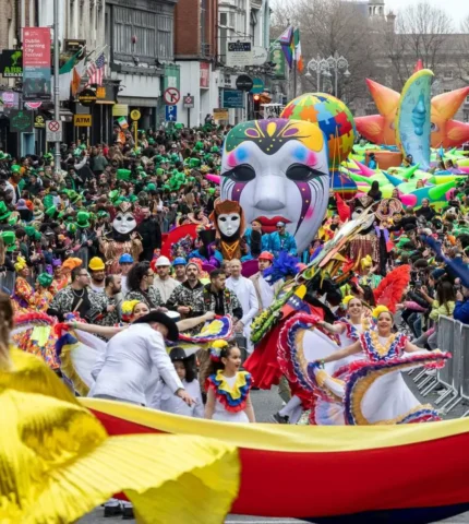 Vibrant parade with colourful costumes and large crowds in Dublin city centre.