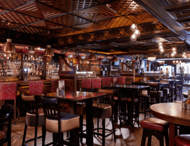 Warm interior of a cosy bar with wooden furniture and sparkling lights.