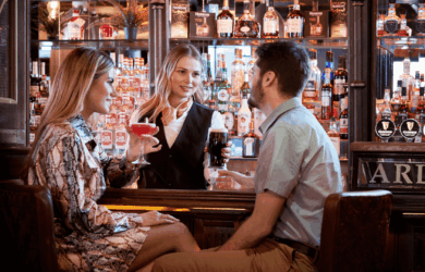 Guests enjoy drinks at the Arlington Hotel bar with a friendly bartender.