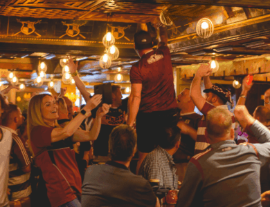 Guests celebrating energetically in a lively, warmly lit hotel bar.