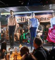 Performers in traditional Irish attire dancing on stage at a lively hotel bar.