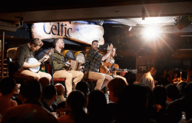 Musicians perform on stage at a lively Dublin bar, engaging a cheerful crowd.