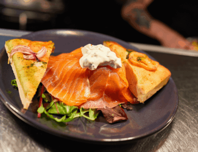Delicious smoked salmon and flatbread dish in a warm, inviting restaurant setting.