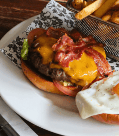 Delicious burger with bacon, cheese, fried egg, and fries at Arlington Hotel bar.