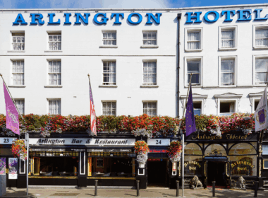 Exterior of Arlington Hotel and Bar in Dublin, adorned with vibrant hanging flowers.
