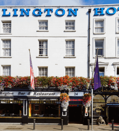 Exterior of Arlington Hotel and Bar in Dublin, adorned with vibrant hanging flowers.