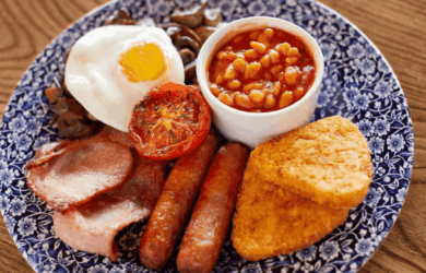 Traditional full English breakfast on a blue floral plate.