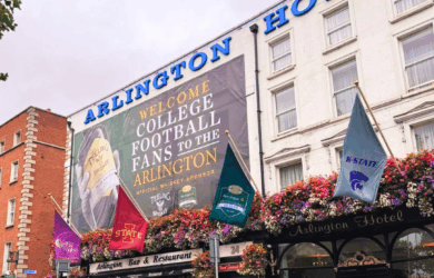 Arlington Hotel with welcoming sign for college football fans and vibrant floral decorations.