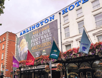 Arlington Hotel with welcoming sign for college football fans and vibrant floral decorations.
