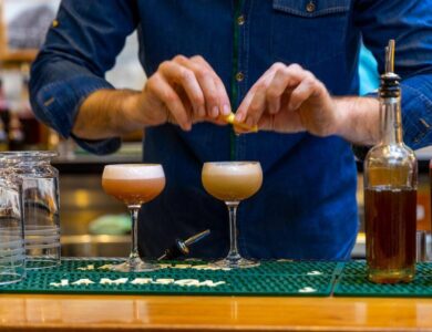 Bartender garnishing cocktails at a stylish hotel bar in Dublin.
