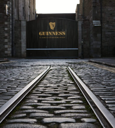 Cobblestone street leading to Guinness brewery entrance in Dublin.