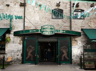 Entrance of Jameson Distillery in Dublin with green awnings and decorative bunting.