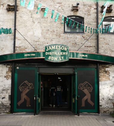 Entrance of Jameson Distillery in Dublin with green awnings and decorative bunting.
