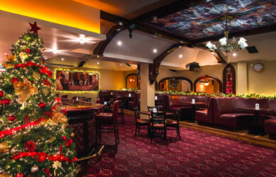 Festive hotel bar with Christmas tree and cosy seating.