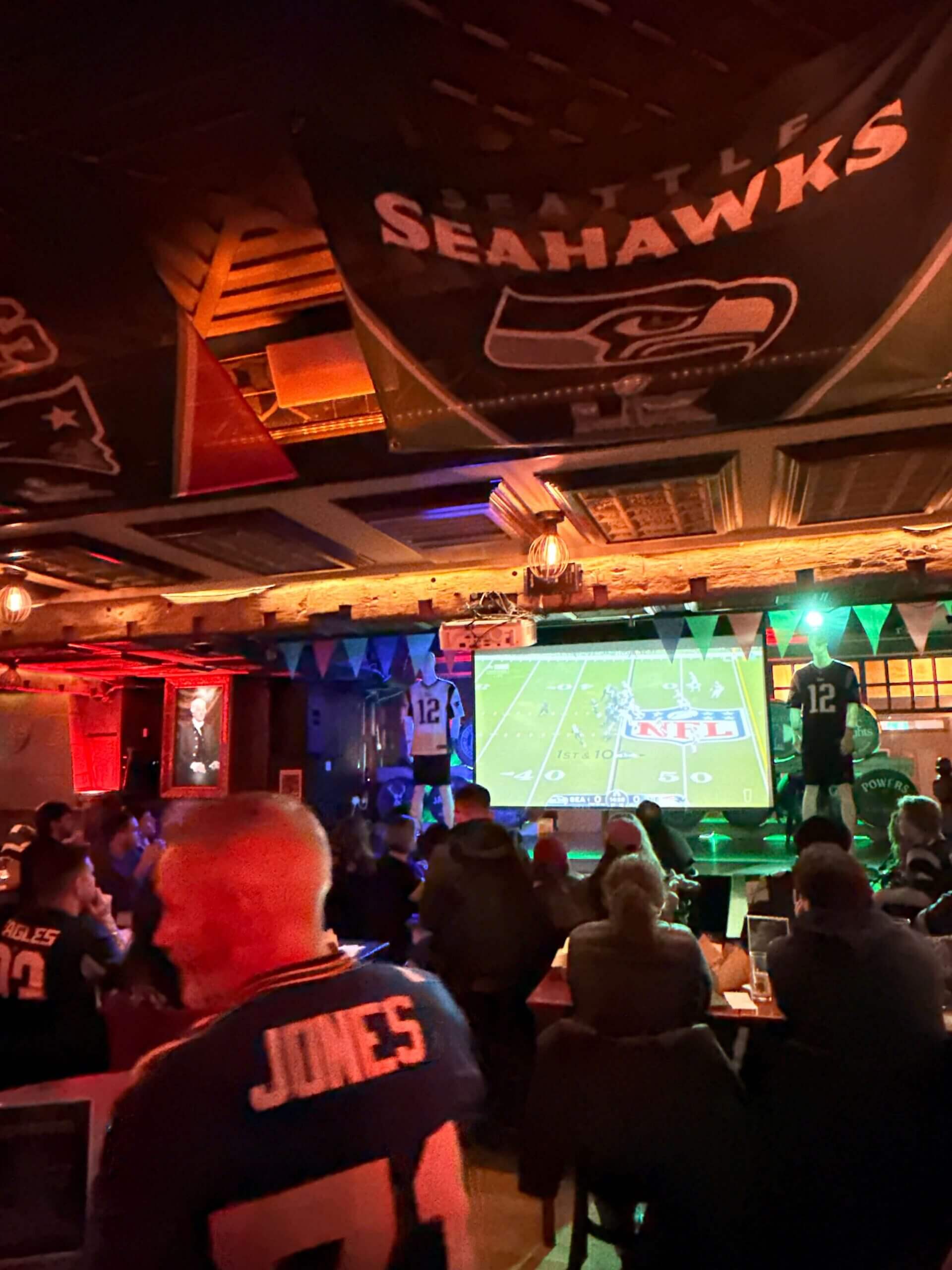 Guests enjoy an NFL game at the Arlington Hotel bar, decked with team flags.