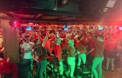 Guests joyfully celebrating in a lively bar atmosphere.