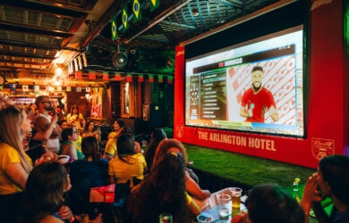 Patrons enjoying a football match at lively Arlington Hotel bar.