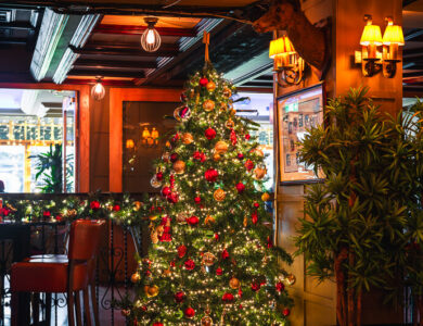 Festive hotel bar with a decorated Christmas tree and warm lighting.