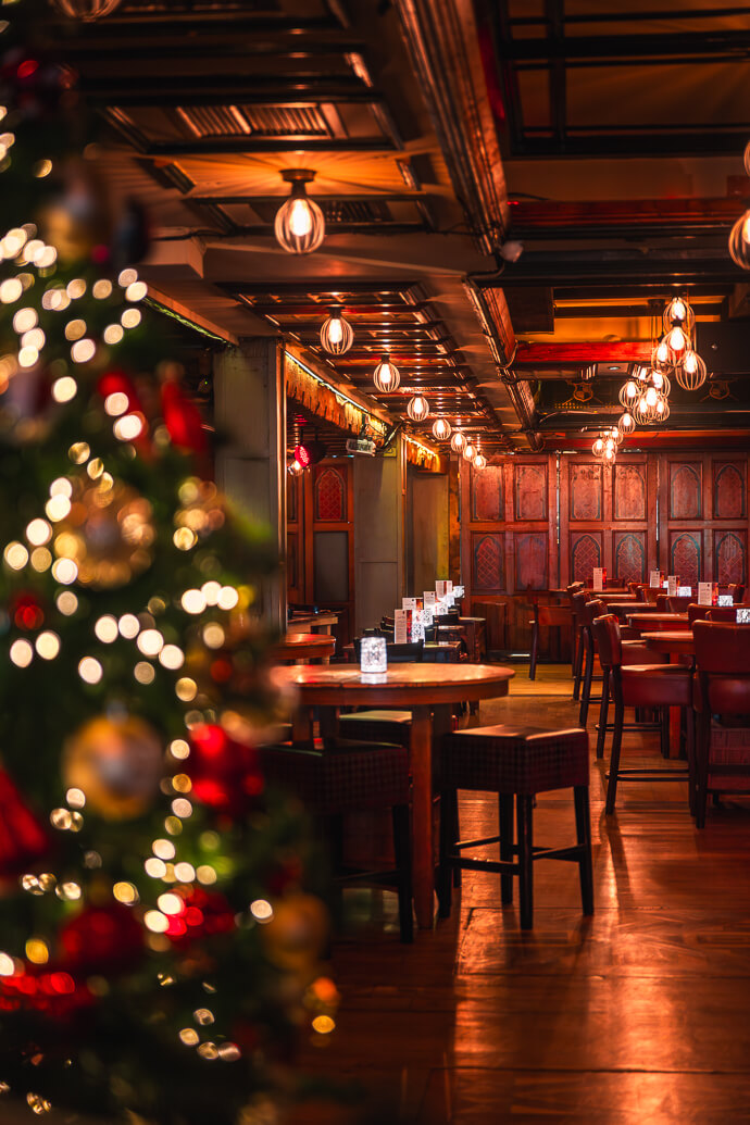 Warm, inviting hotel bar with festive decorations and intimate seating arrangements.