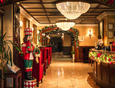 Luxurious hotel lobby with festive decor and elegant chandeliers.