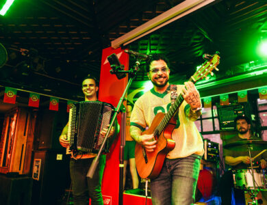 Musicians performing live in a vibrant Dublin hotel bar with smiling audience.