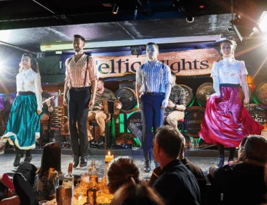 Traditional Irish dancers performing at a lively bar with an engaged audience.
