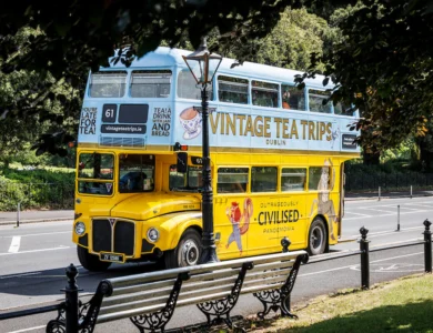 Vintage double-decker bus on Dublin street offering tea tours.