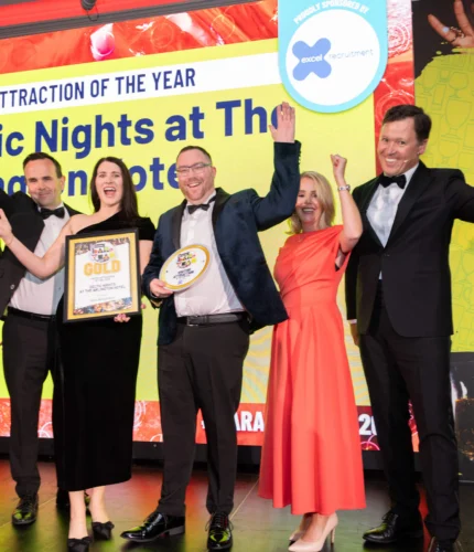 Group celebrating award at elegant hotel event venue.