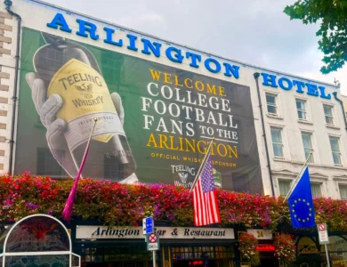 Arlington Hotel exterior with welcoming banner and vibrant flowers.