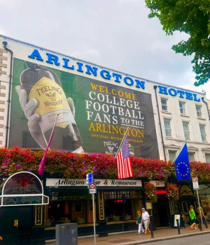 Arlington Hotel exterior with welcoming banner and vibrant flowers.
