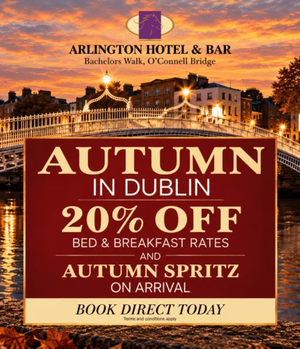 Evening riverside view of Ha'penny Bridge with autumn lights, promotional sign reading "AUTUMN IN DUBLIN 20% OFF BED & BREAKFAST RATES" and a spritz cocktail in foreground